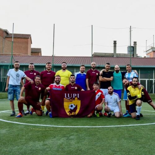 Squadra di calcio a 5 che posa per una fotografia su campo di calcio